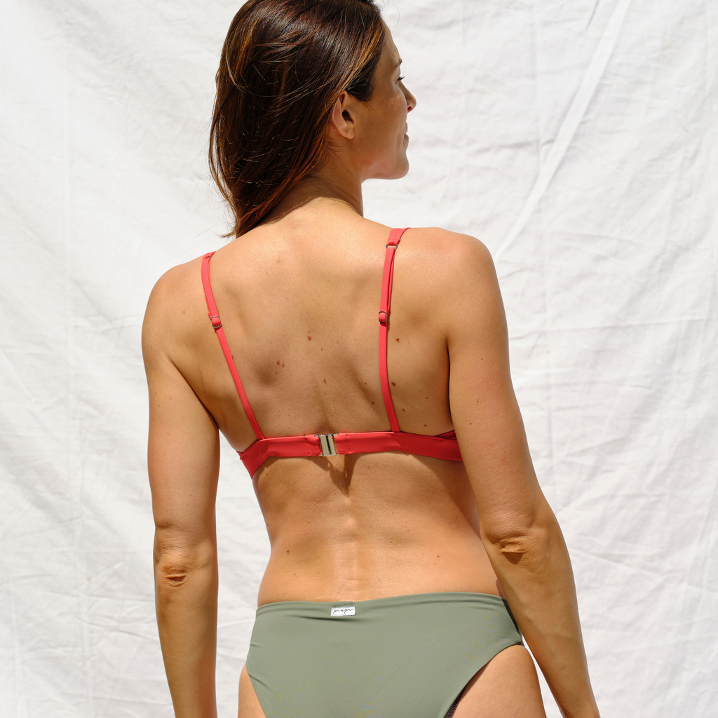 Woman wearing a red bikini top and khaki bottom by Paupa, back view
